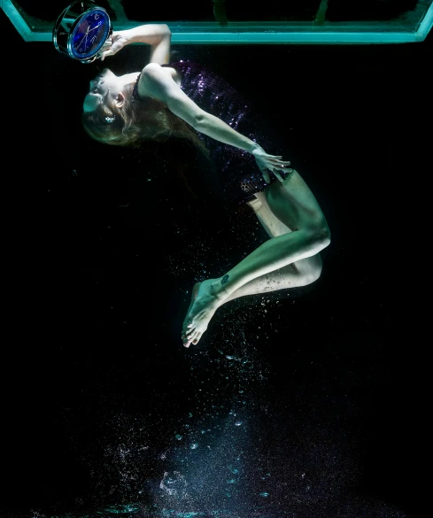 a woman that is floating in the water, by Dan Luvisi, art photography, olympic diving springoard, on black background, bubbles, deep green