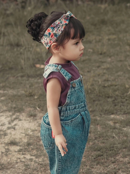 a little girl standing on top of a skateboard, a colorized photo, pexels contest winner, wearing blue jean overalls, wearing the number 1 headband, with dark hair tied up in a bun, thoughtful )