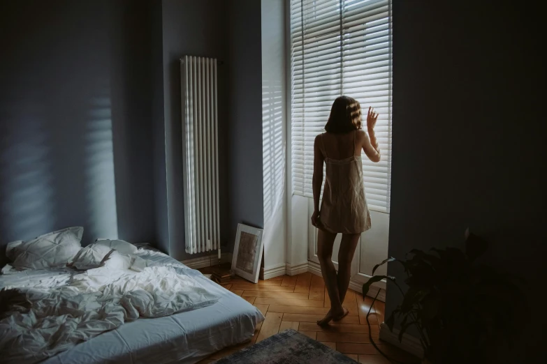 a woman is standing in front of a window in the dark