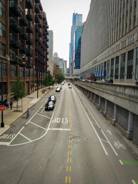 a street filled with lots of traffic next to tall buildings, a photo, location [ chicago ( alley ) ], photo 8 k, city bay bridge aqueduct, leaked image