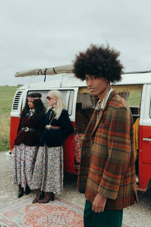 a man standing in front of a red and white van, an album cover, trending on unsplash, renaissance, tartan garment, long afro hair, group photo, photo from vogue magazine