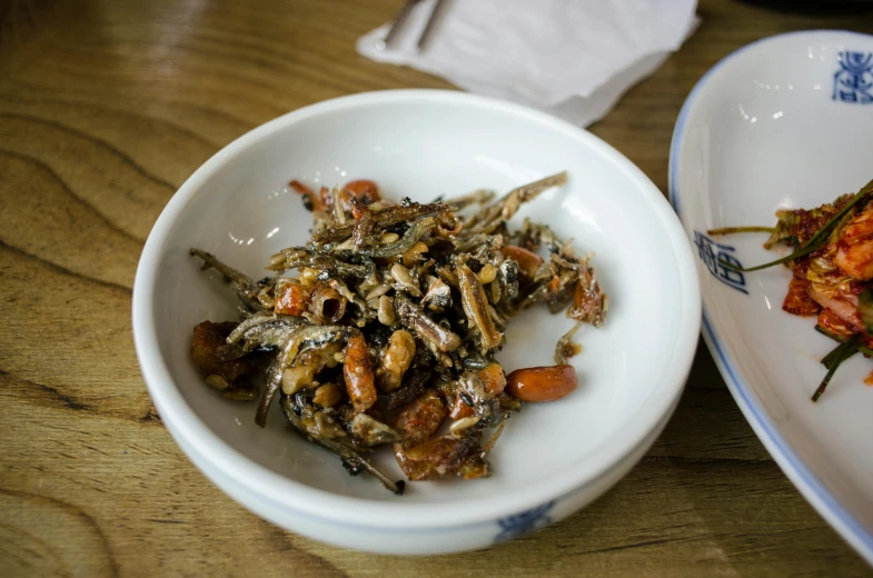 a close up of two plates of food on a table, unsplash, mingei, locusts and flies, pengzhen zhang, beans, dried flower