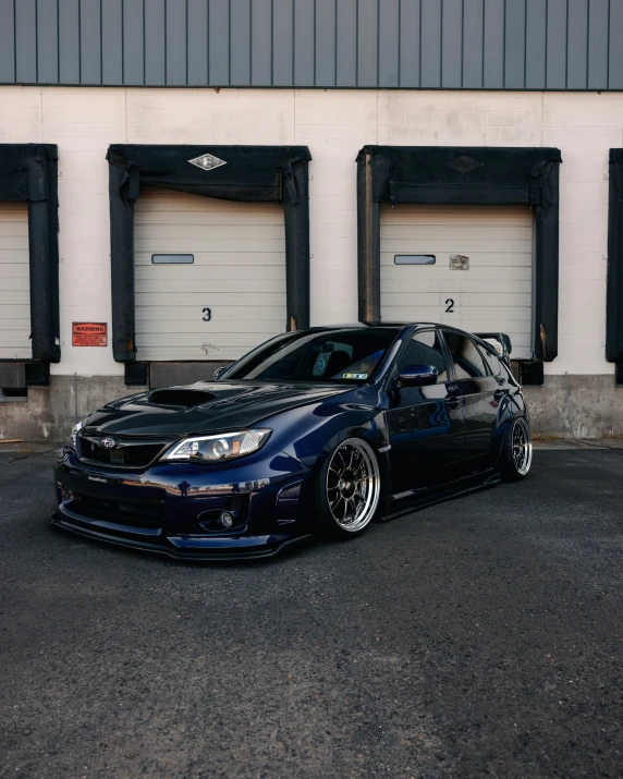 a dark colored car parked in front of a building