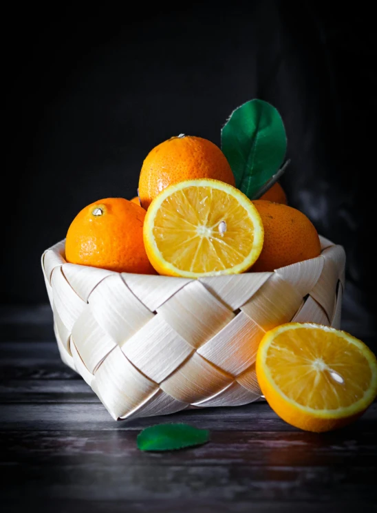 a basket filled with oranges sitting on top of a wooden table, in front of a black background, garnish, full product shot, orange racing stripes