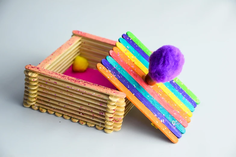 a wooden box with pops sticking out of it, inspired by Eden Box, rainbow fur, catapult, thumbnail, powder