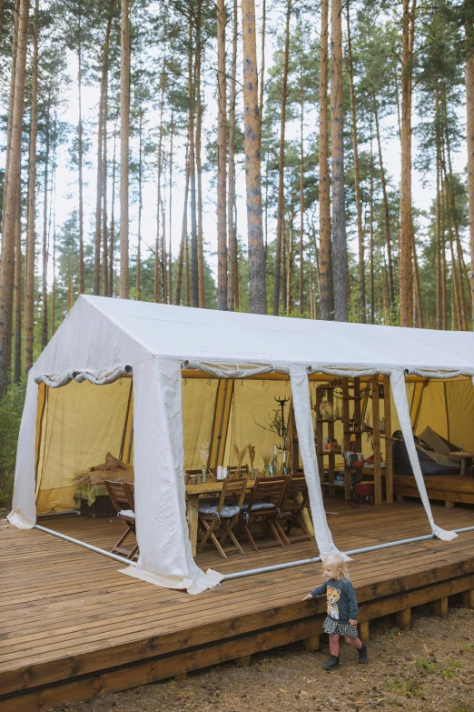 a white tent sitting on top of a wooden deck, kalevala, saloon exterior, various styles, pine forest