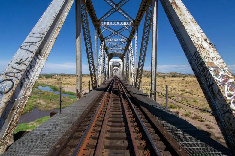 a very tall metal bridge spanning over a wide body of water