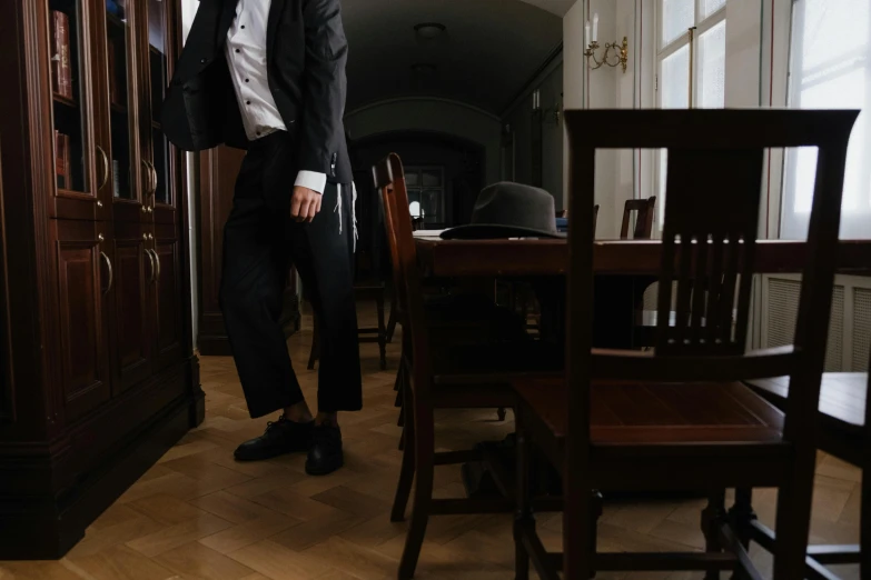 a man stands next to several chairs in a room