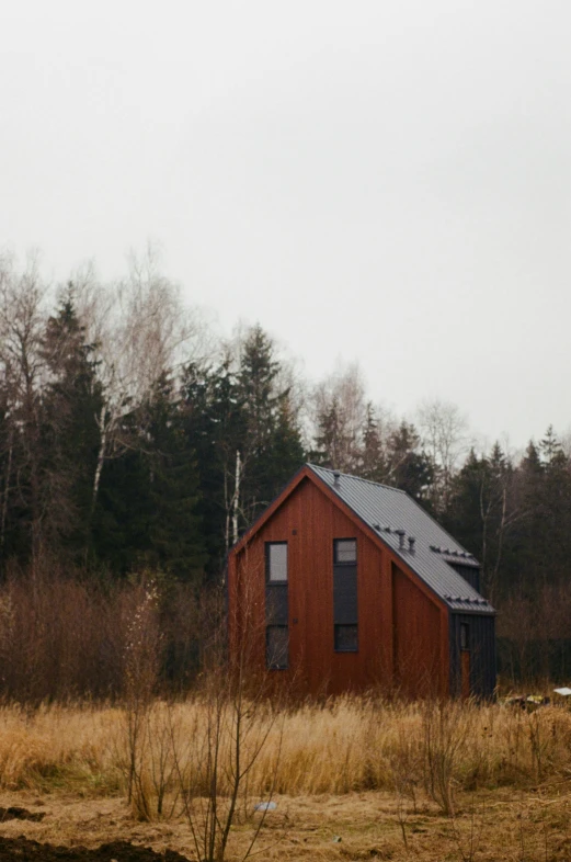 a small building in a field next to trees