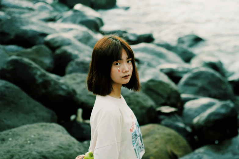 a woman standing in front of a body of water, inspired by Itō Shinsui, unsplash, portrait jisoo blackpink, white french bob, photographed on damaged film, at the seaside