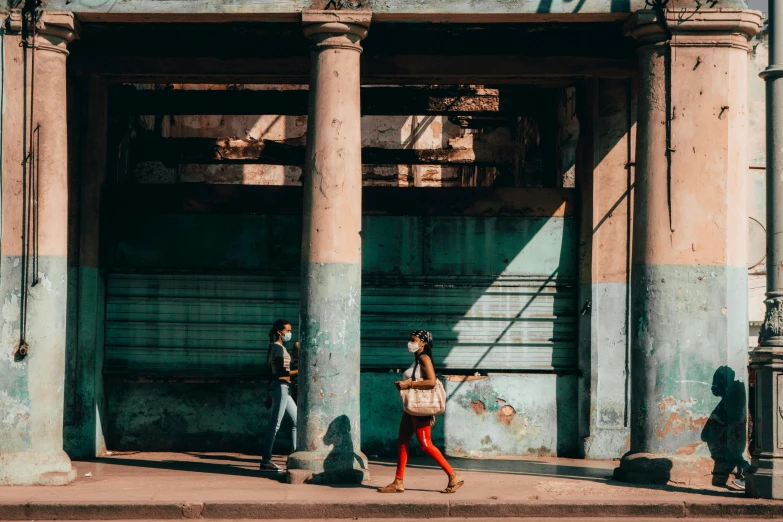 a girl and boy are walking outside a building