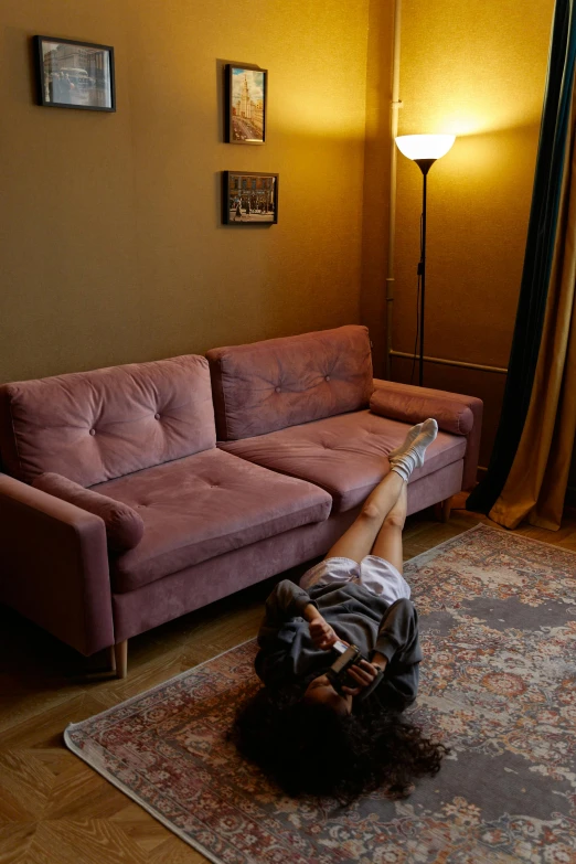 a woman laying on top of a purple couch