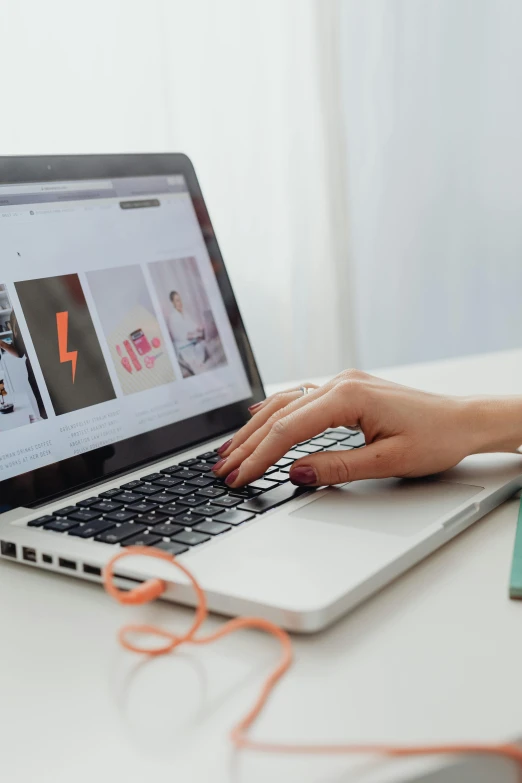 a woman is typing on her laptop on the desk