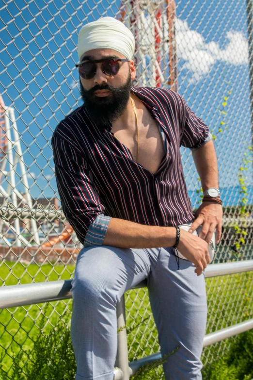 man sitting on fence leaning against rail looking out at sky