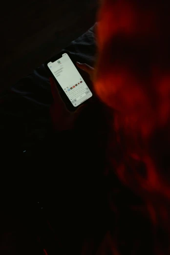 a close up of a person holding a cell phone, by Adam Rex, happening, fire hair, dark red, epk, snapchat