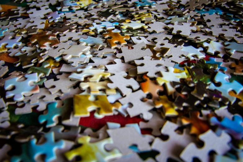 a pile of puzzle pieces sitting on top of a table, a jigsaw puzzle, by Daniel Lieske, pexels, 2 5 6 x 2 5 6, shattering, photo taken in 2018, curiosity