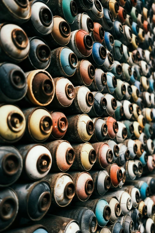 a bunch of spray cans stacked on top of each other, inspired by Andreas Gursky, unsplash, graffiti, rusty colors, many giant eye balls, minn, spare parts