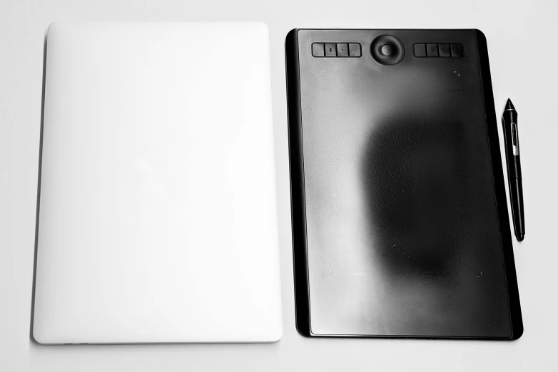 a black and white photo of a notepad and a pen, a minimalist painting, computer art, silicone cover, front and back view, lit from bottom, top down camera angle