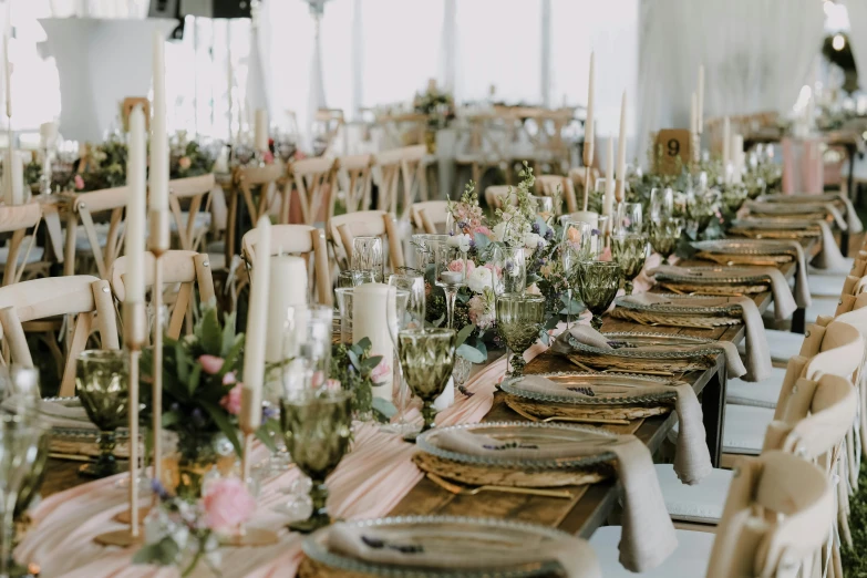 a long table set for dinner with flower arrangement