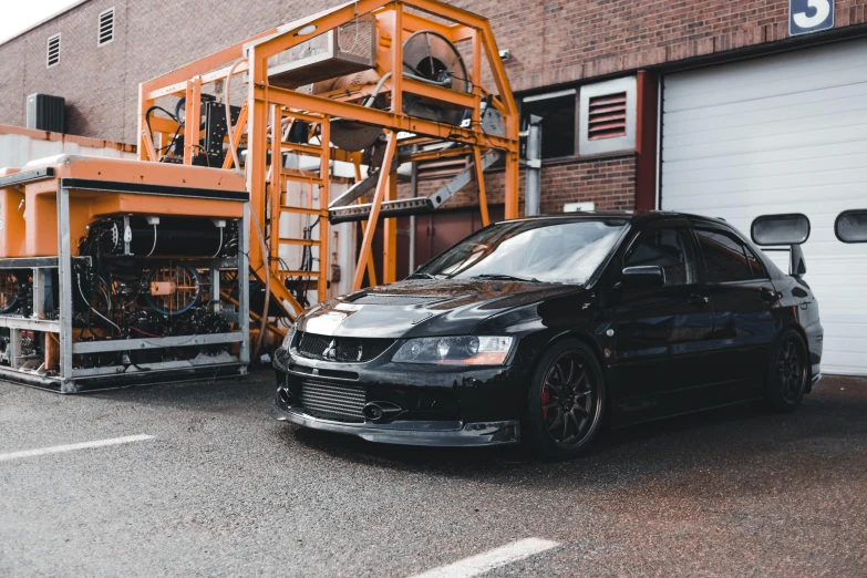 a black car parked in front of a building, unsplash, industrial machinery, japanese drift car, 2000s photo, high quality product image”