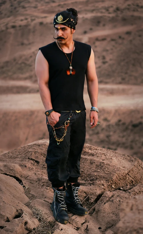 man in steampunk standing on rock with hat and necklace