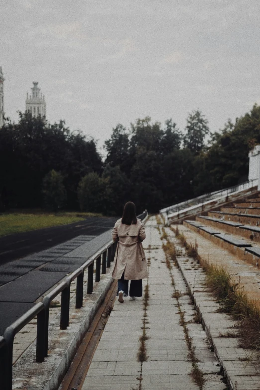 a woman walking down a set of train tracks, unsplash contest winner, socialist realism, standing in a stadium, in a park, in russia, steps leading down