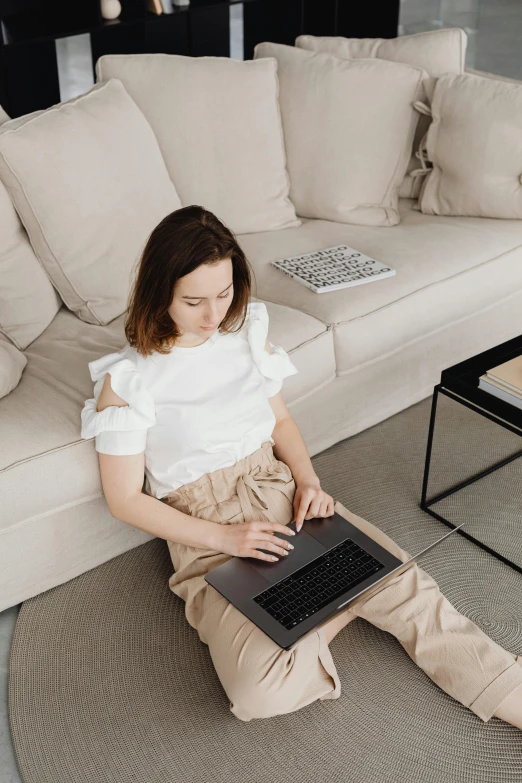 a woman sitting on the floor using a laptop, trending on pexels, renaissance, sitting on a couch, white sleeves, low quality photo, centered shot