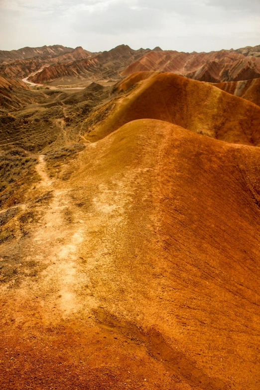 several layers of red dirt with hills and ridges in the background