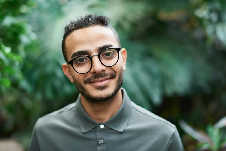 a man with glasses is smiling for the camera