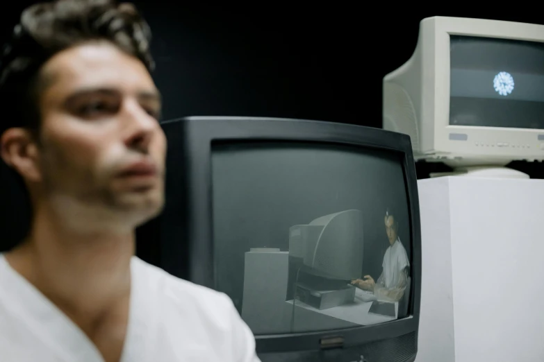 man with face in distorted mirror next to old fashioned television