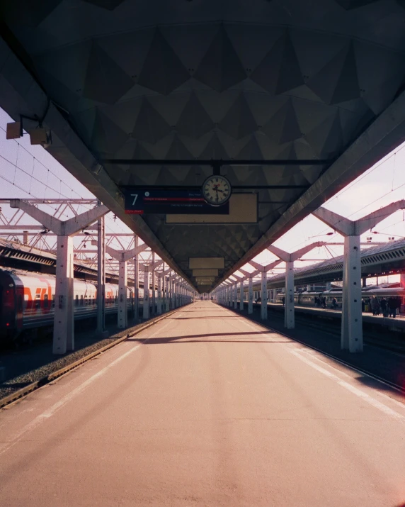 a large long train on a steel track, a polaroid photo, unsplash contest winner, bus station, shades of aerochrome, view from below, instagram story