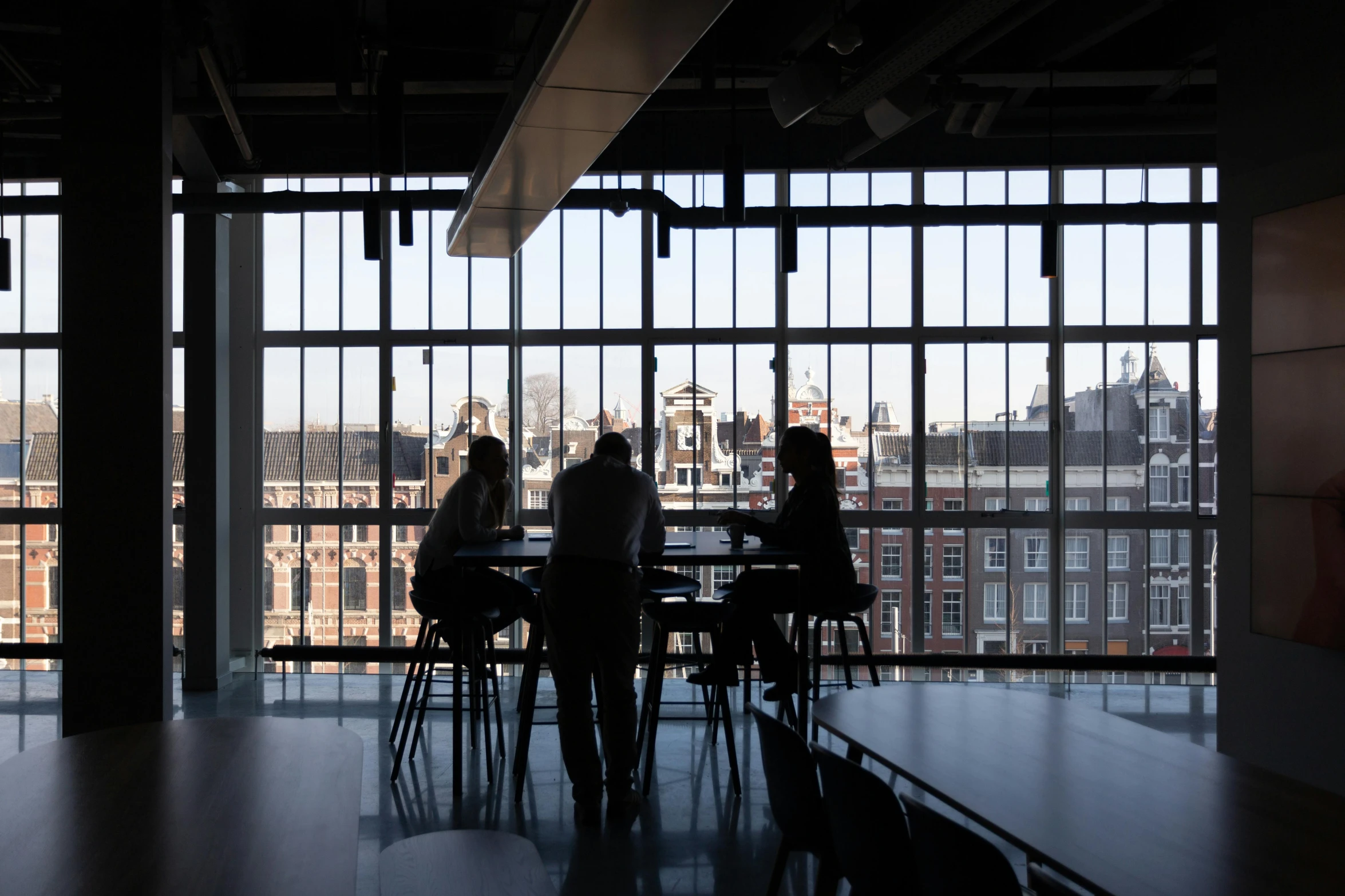 a group of people sitting at a table in front of a window, by Jan Wijnants, pexels contest winner, modernism, inside a science facility, silhouetted, amsterdam, view from the back