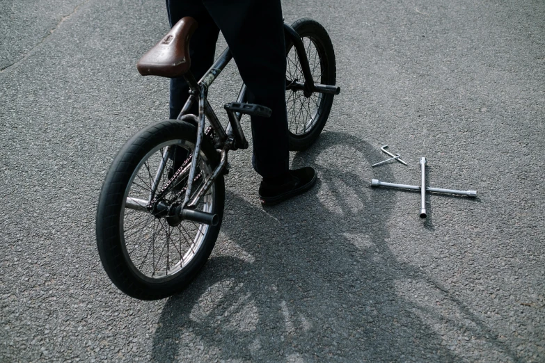 a man riding a bike on top of a street, exploded parts assembly, detailed shot legs-up, lasso tool, on a parking lot