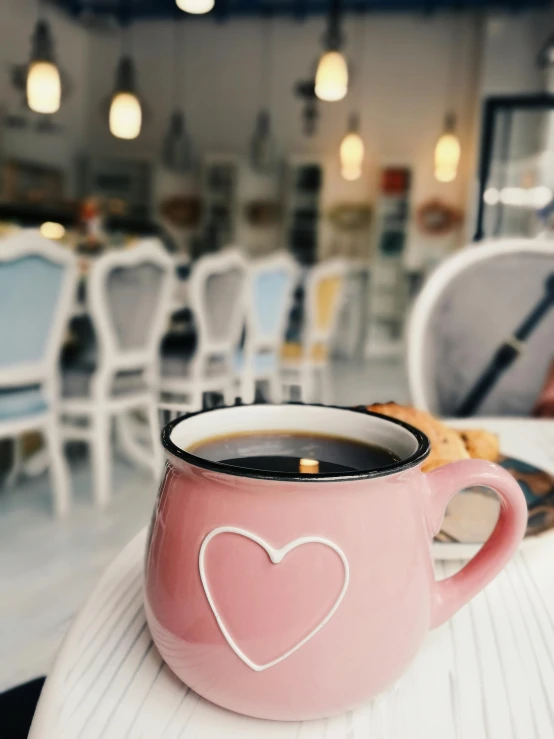 a cup of coffee sitting on top of a table, pink accents, thumbnail