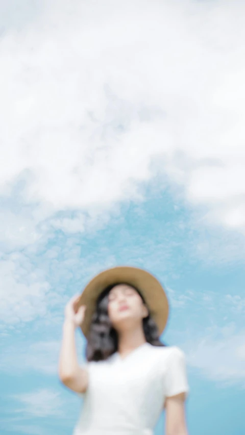 a woman in white is wearing a large hat