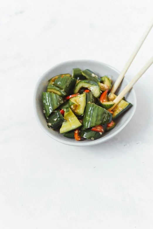 a bowl of vegetables with chopsticks in it, snining stars, white bg, square, pickle