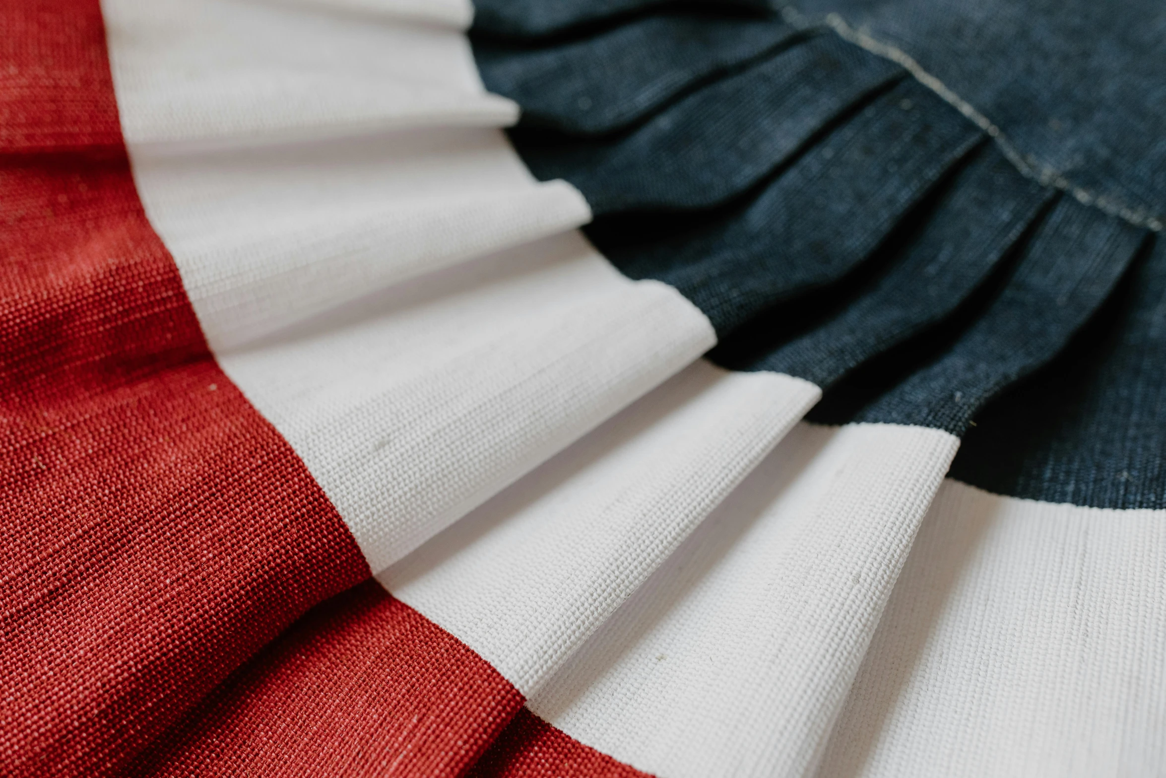 a close up of a red, white and blue flag, inspired by Jean Hélion, trending on unsplash, coated pleats, award - winning crisp details, linen, rosette