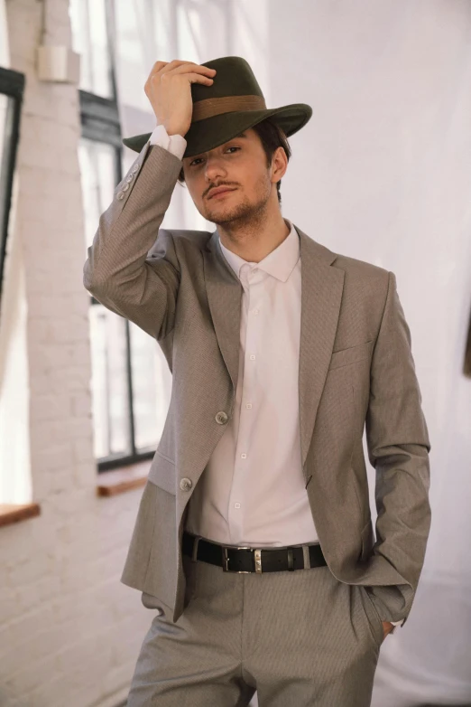 a man is posing with his hat over his head