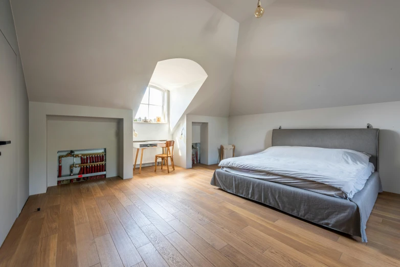 a bedroom with wood floors and a vaulted ceiling