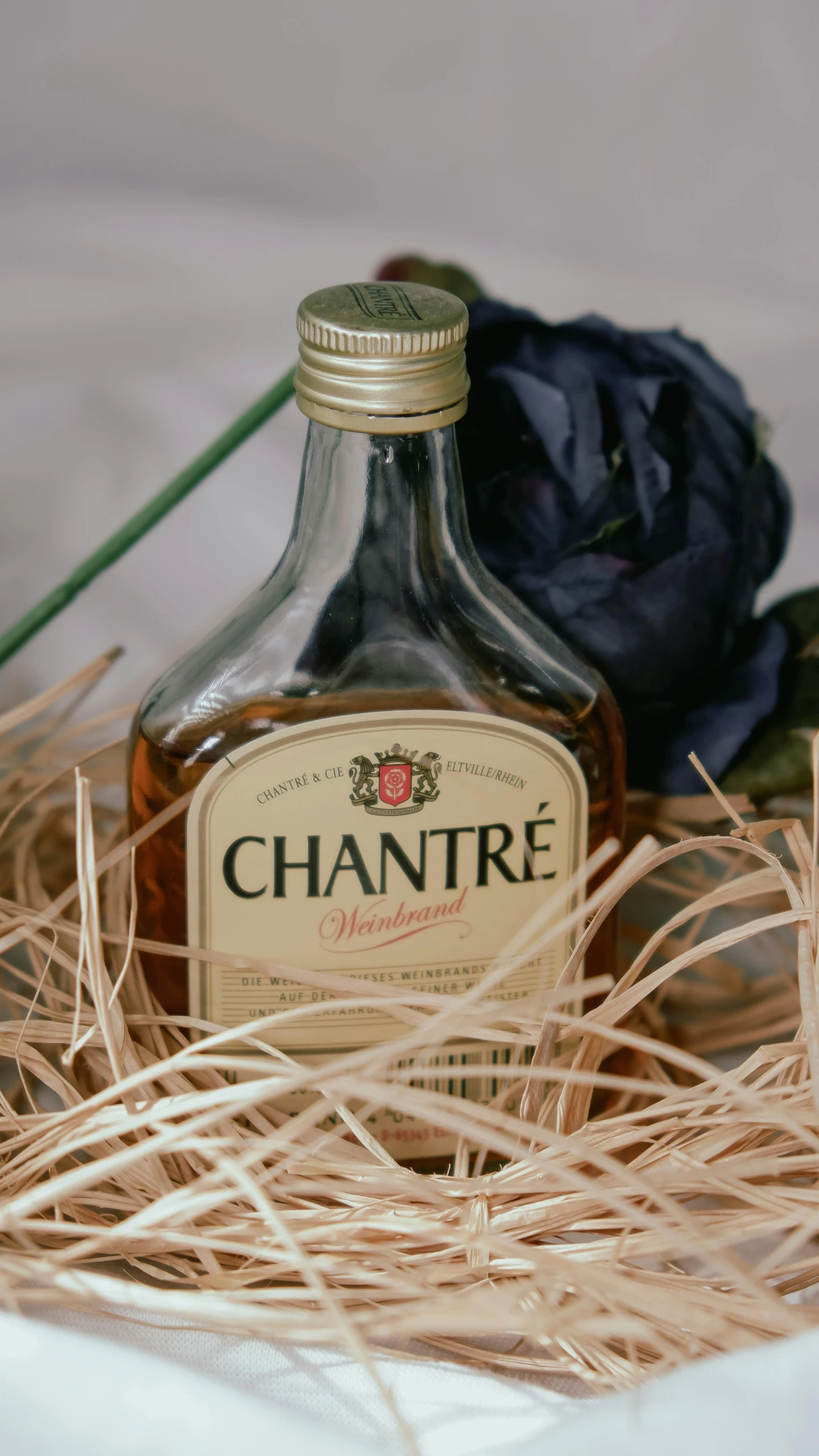 a bottle of liquor sitting on top of a bed of straw, inspired by Charles Le Roux, chaste, thumbnail, normandy, press shot