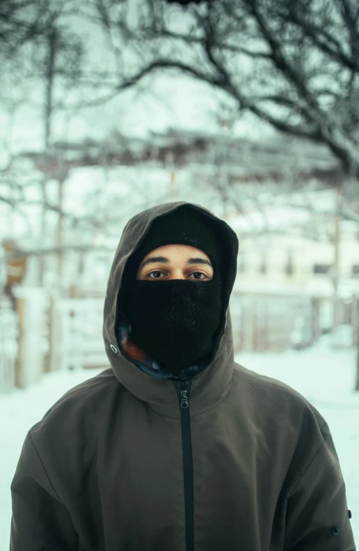 a man wearing a black hoodie is outside in the snow