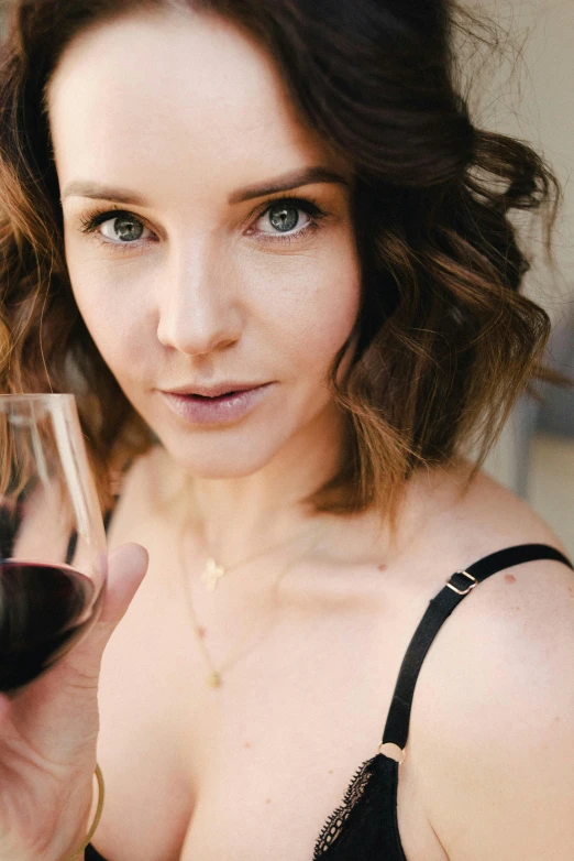 a woman in  holding up a glass of wine