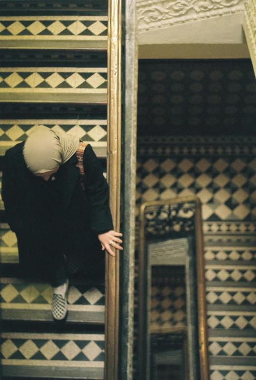 a person walking down the stairs in front of some mirrors