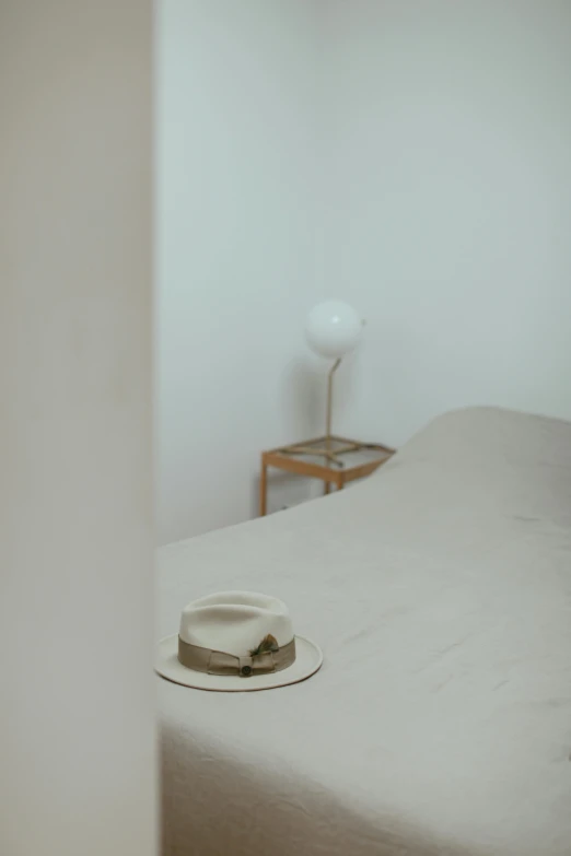 there is a white hat on the top of a bed