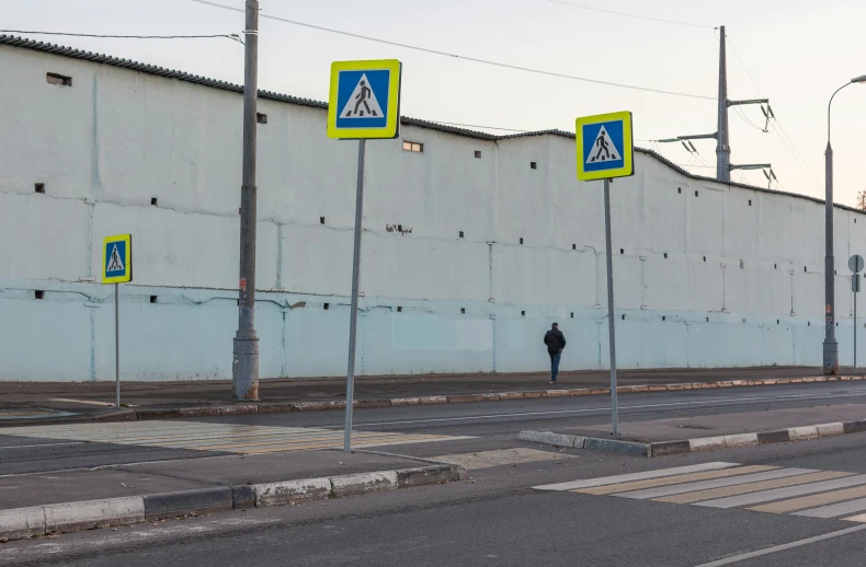 a person standing on the side of a road, by Sven Erixson, postminimalism, rostov city, polygonal iron steel walls, street signs, warehouses