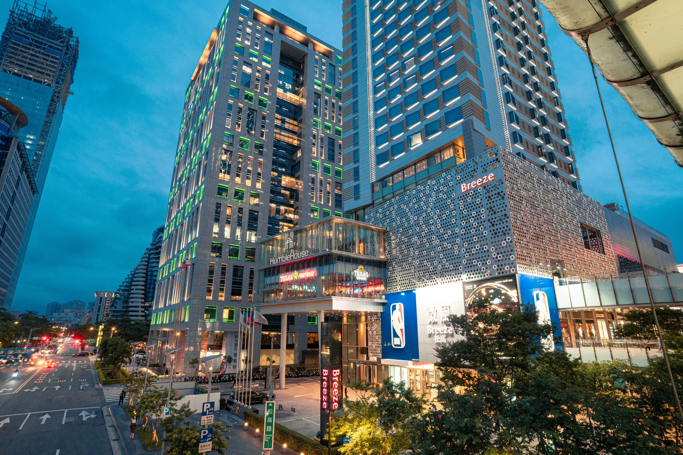 a very tall building in the middle of a city, neon lights above shops, skyscrapers with greenery, exterior shot, square