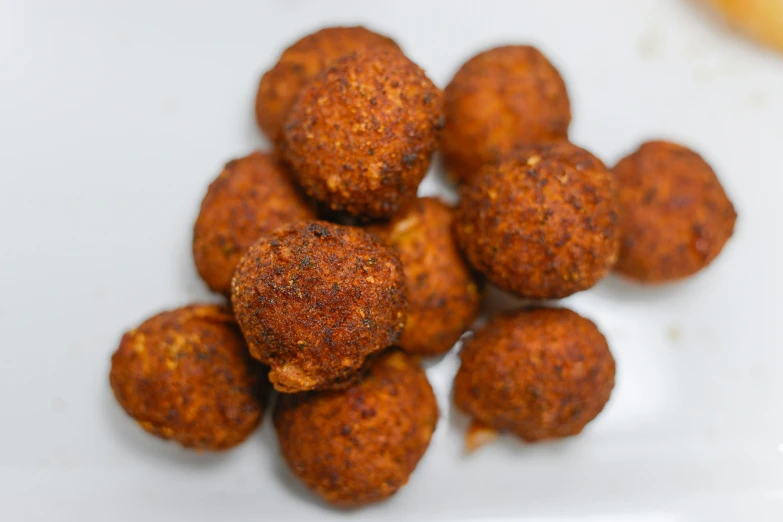 some meatballs on a white plate with salt sprinkled on them