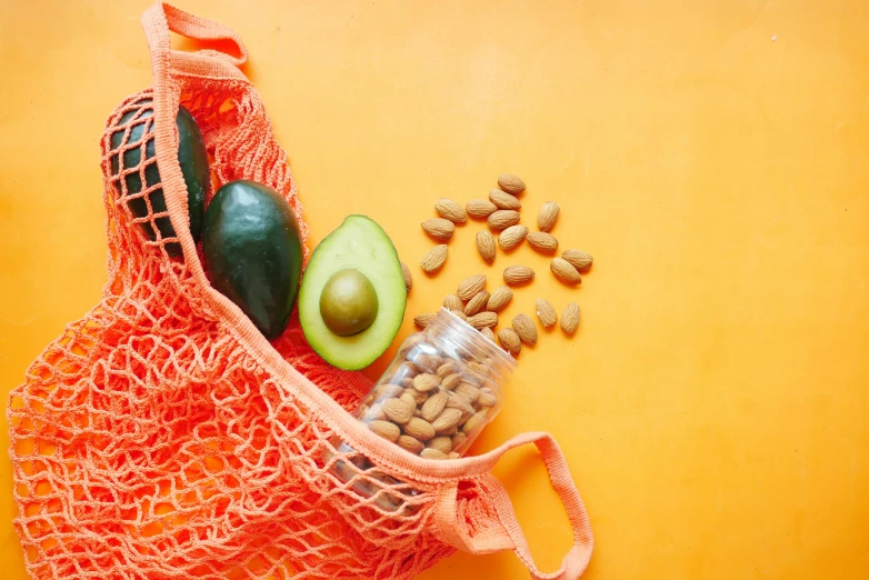 a bag of nuts, avocado, and an avocado on a yellow background, by Carey Morris, pexels, orange halter top, cloth wraps, veggies, thumbnail