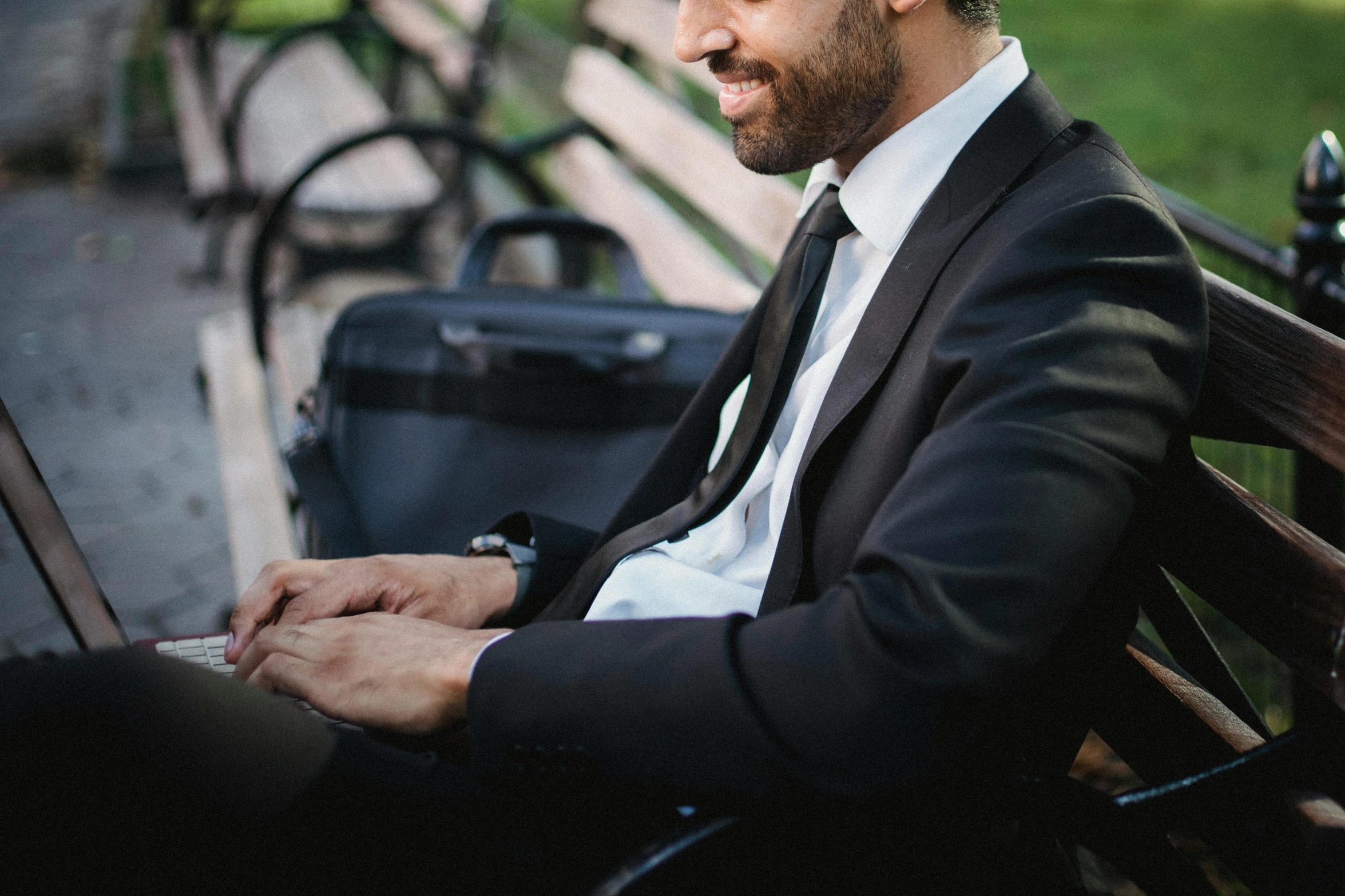 a man sitting on a bench using a laptop, pexels contest winner, black tie, profile image, well trimmed beard, formal wear