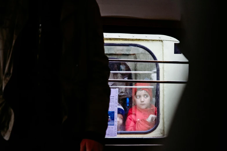 a person looking out the window of a train, inspired by Steve McCurry, little girl, square, ukraine. photography, trending photo